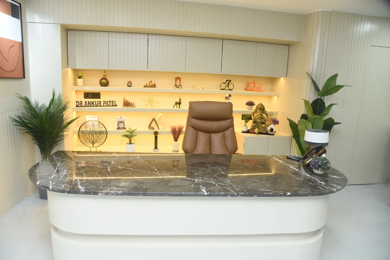 Consultation desk with Dr. Ankur Patel’s name and awards on the shelves behind it