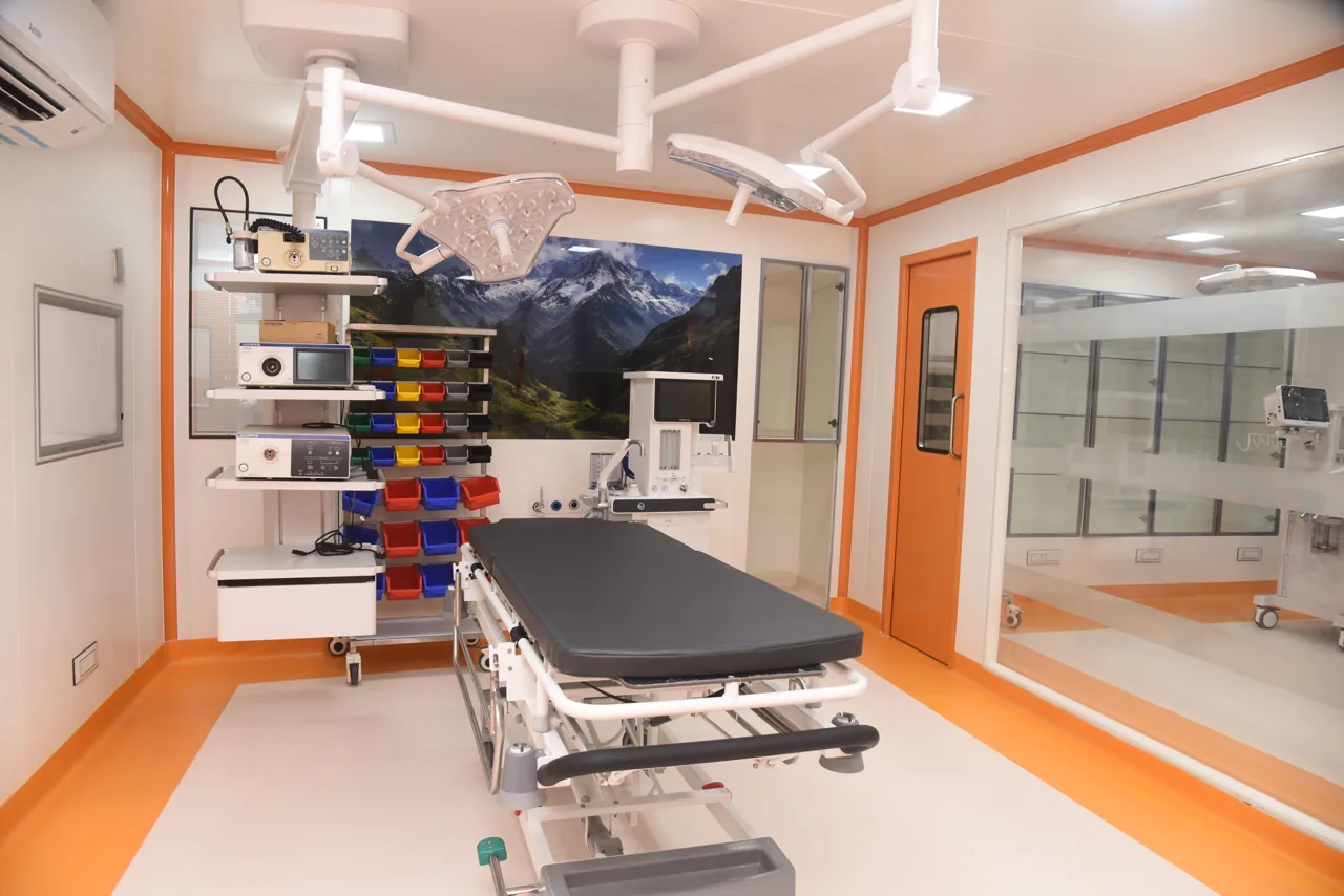 Operating theatre with a surgical table, overhead lights and equipment tower